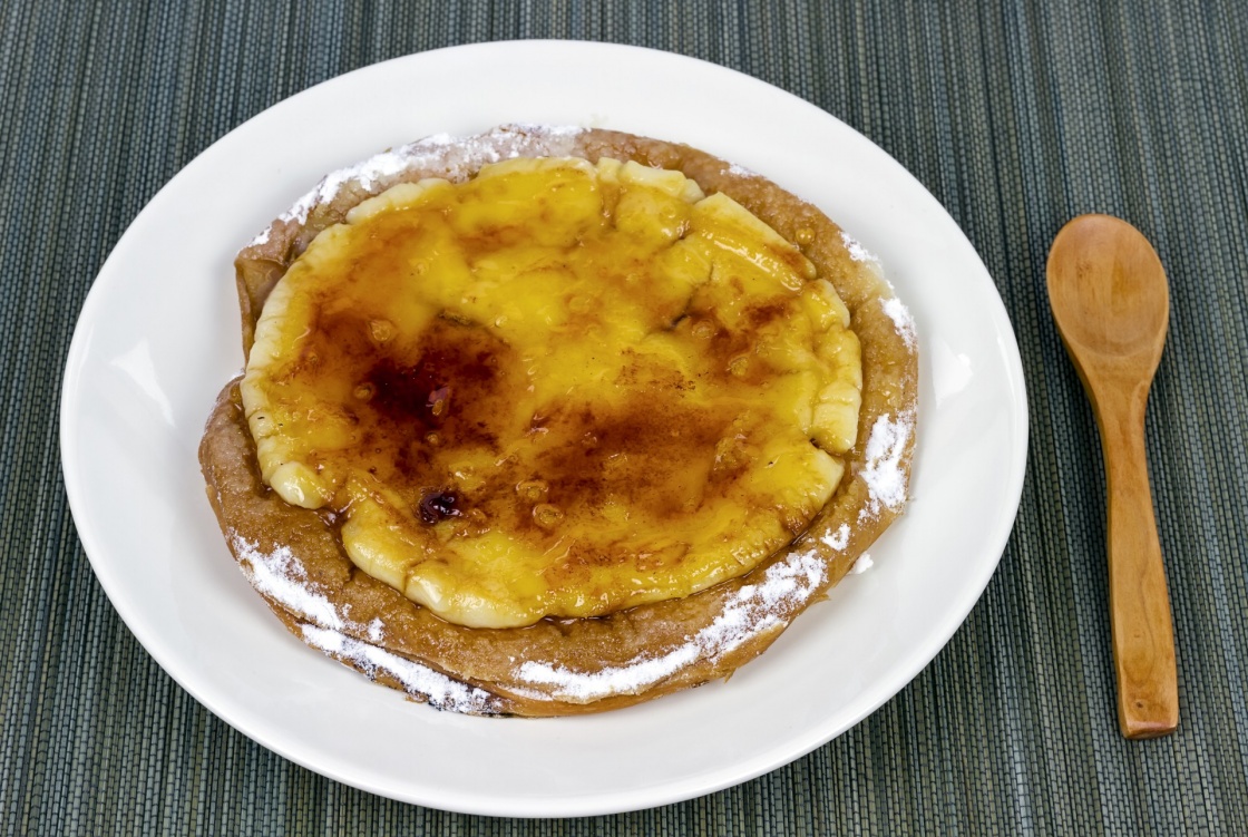 Typical ensaimada de Mallorca with a layer of burnt sugar and Catalan custard